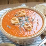 vegan tomato soup in bowl with chopped basil and croutons