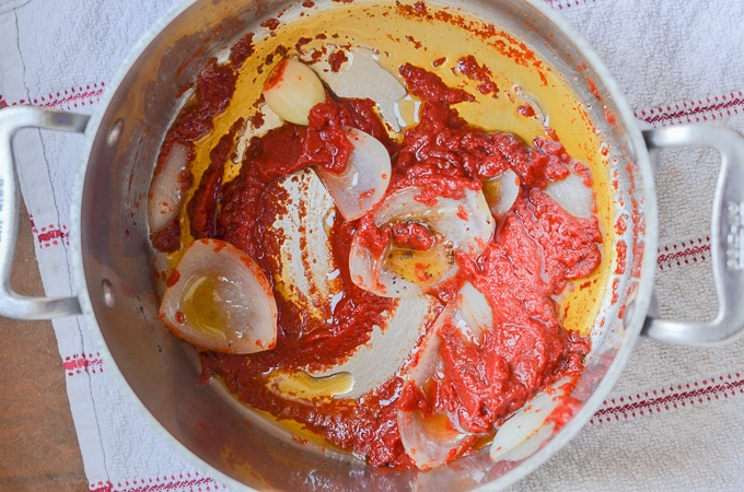 Stir tomato paste in soup pot.