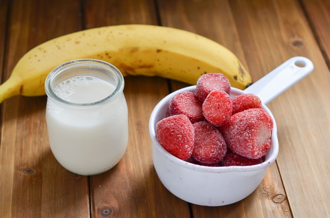 ingredients for strawberry banana smoothie on counter.