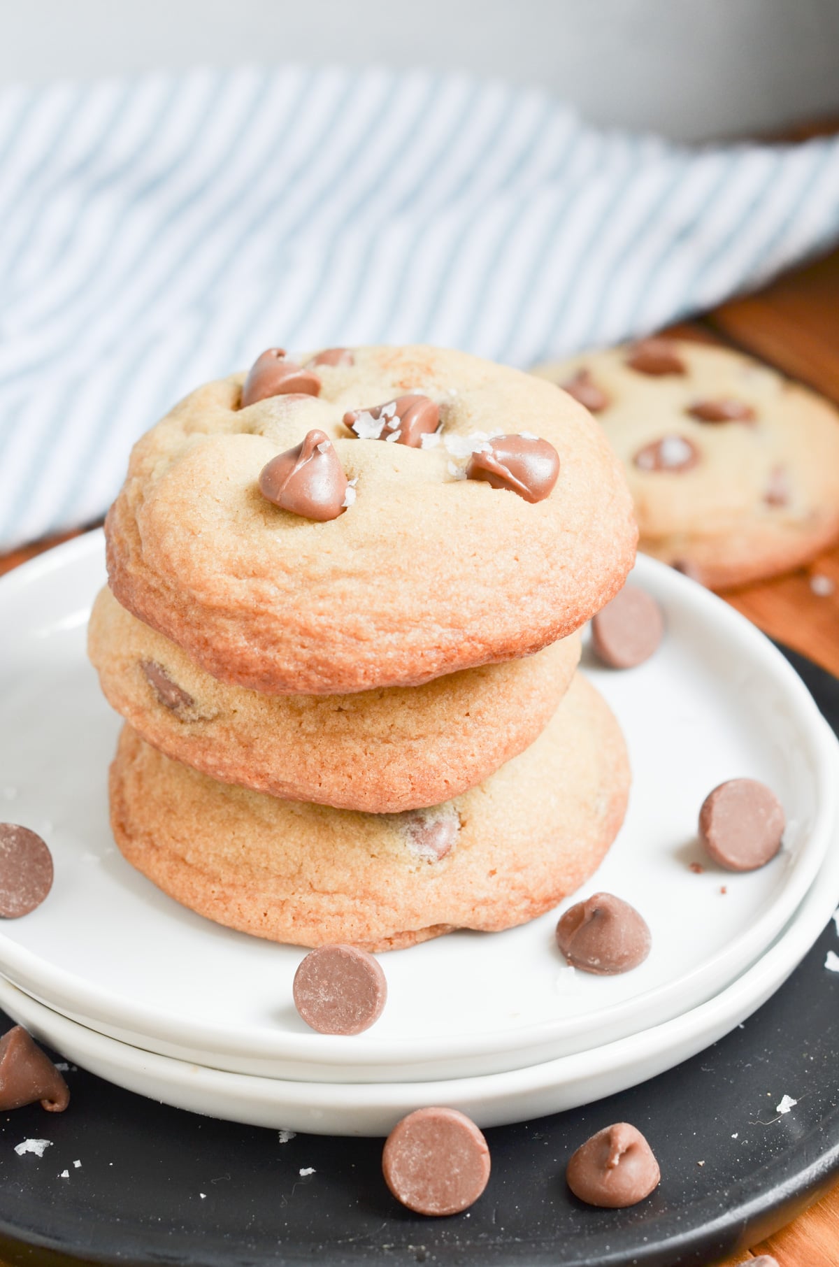 chocolate chip cookies stacked on a white plate.