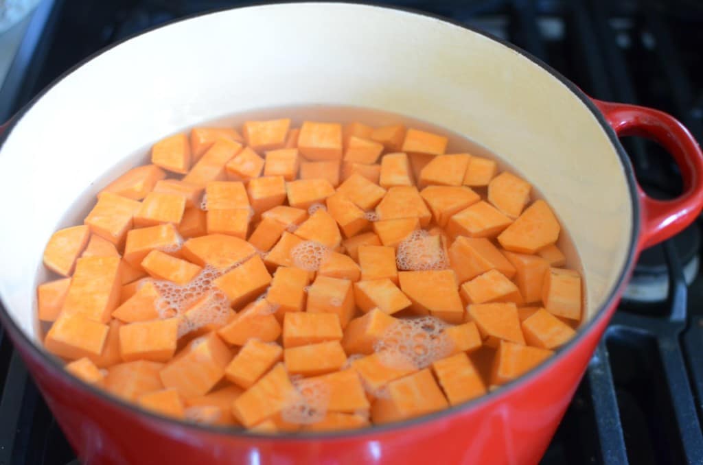 Cut Sweet Potatoes covered in water in stock pot on stove - 24 Carrot Kitchen