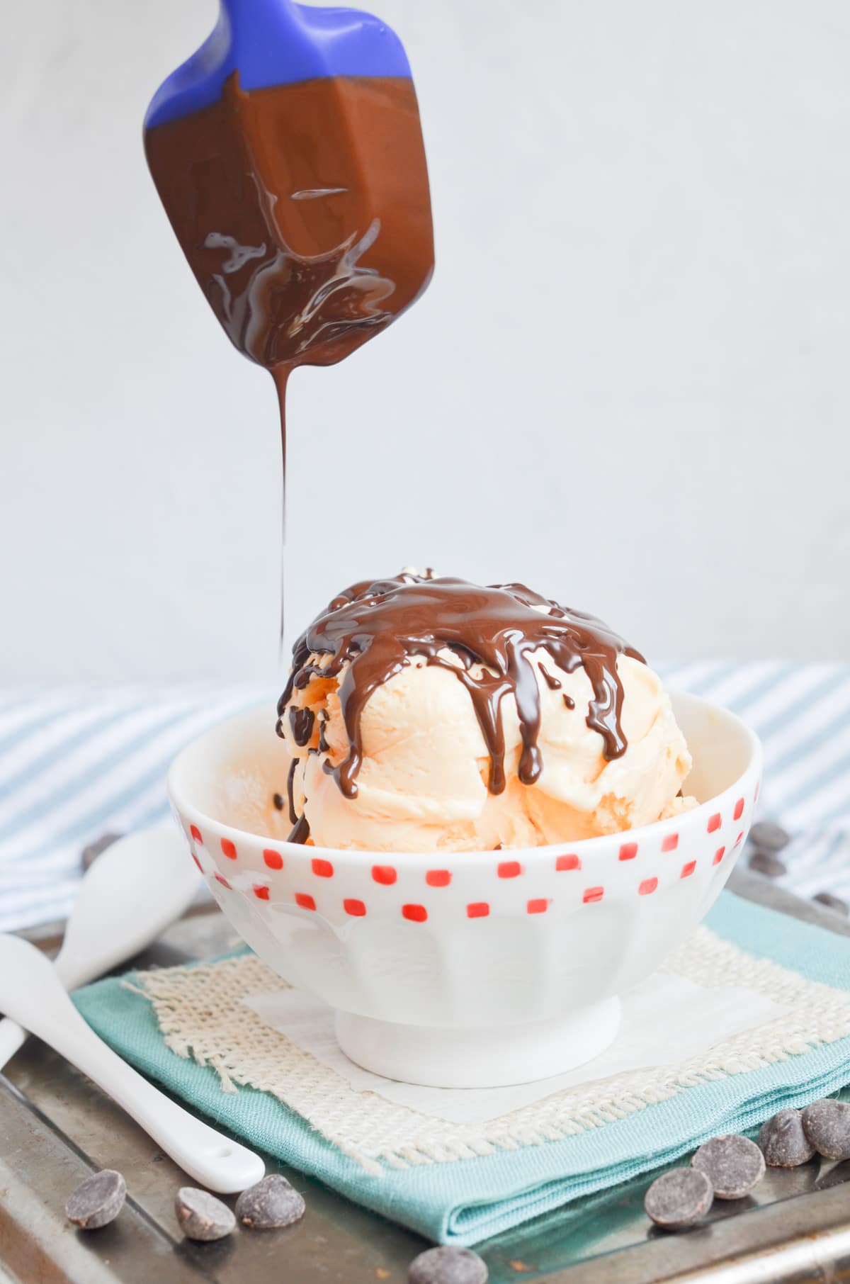 chocolate shell drizzled on vanilla ice cream in bowl.