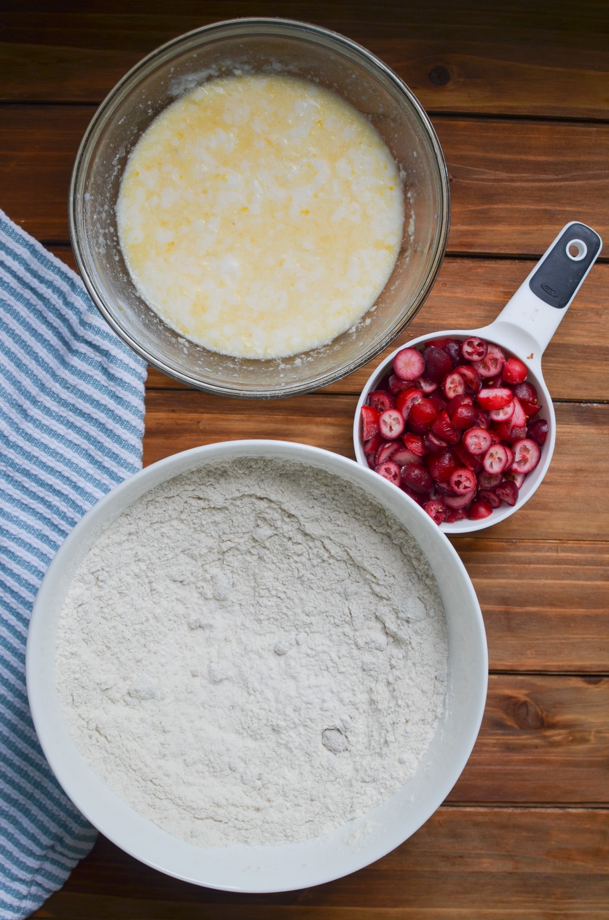 ingredients for cranberry orange bread in bowls on counter.