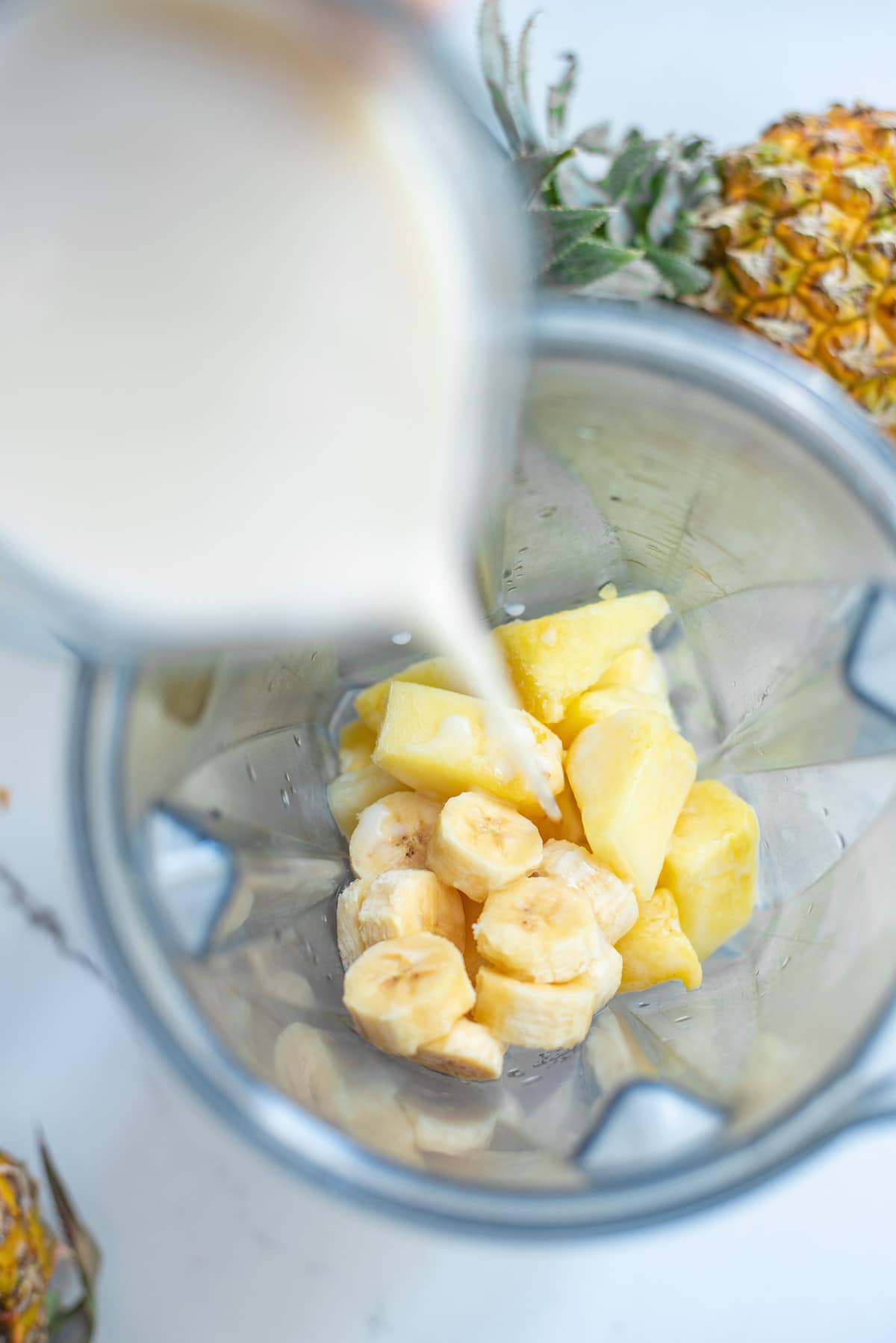 ingredients for pineapple smoothie in a blender.