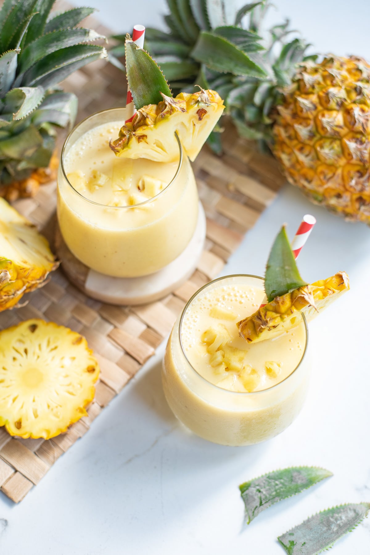 two pineapples smoothies in glasses.