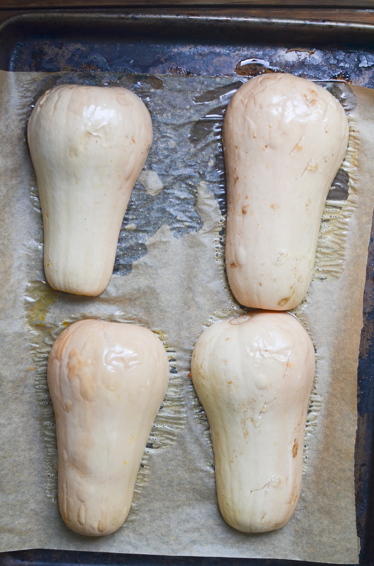 two butternut squashes cut in half on baking sheet roasted.