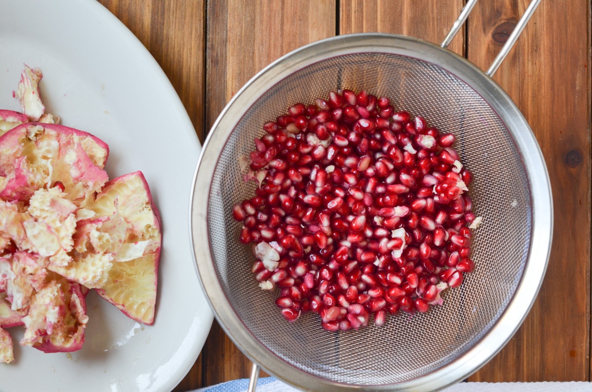 pomegranates in a strainer.