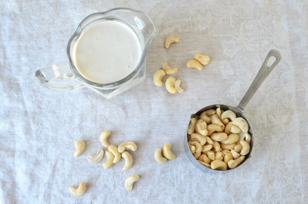 Cashew Cream in glass pitcher and cashews in measuring cup - 24 Carrot Kitchen