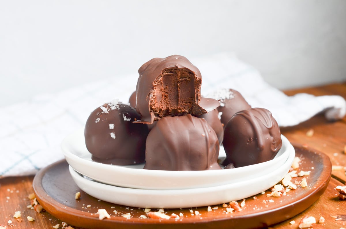 chocolate truffles dipped in chocolate on a plate.