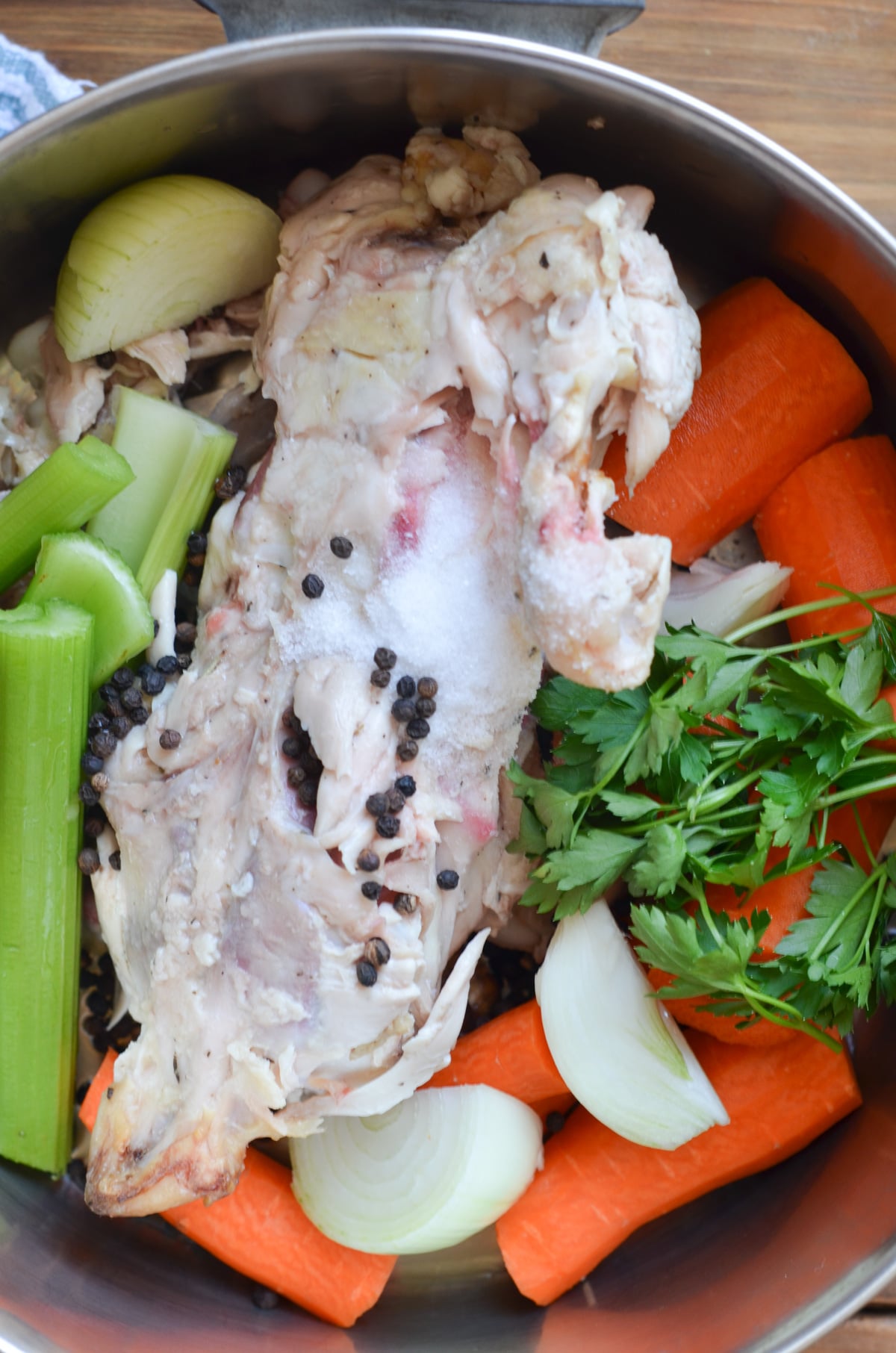 vegetables, chicken bones, herbs, spices in bottom of soup pot.