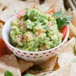 Guacamole in a bowl with tortilla chips.