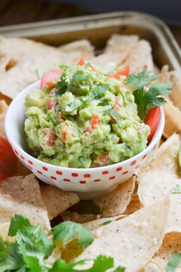 Guacamole in a bowl with tortilla chips.
