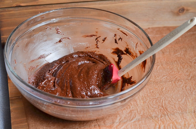 Dry ingredients mixed into egg and chocolate batter in bowl.