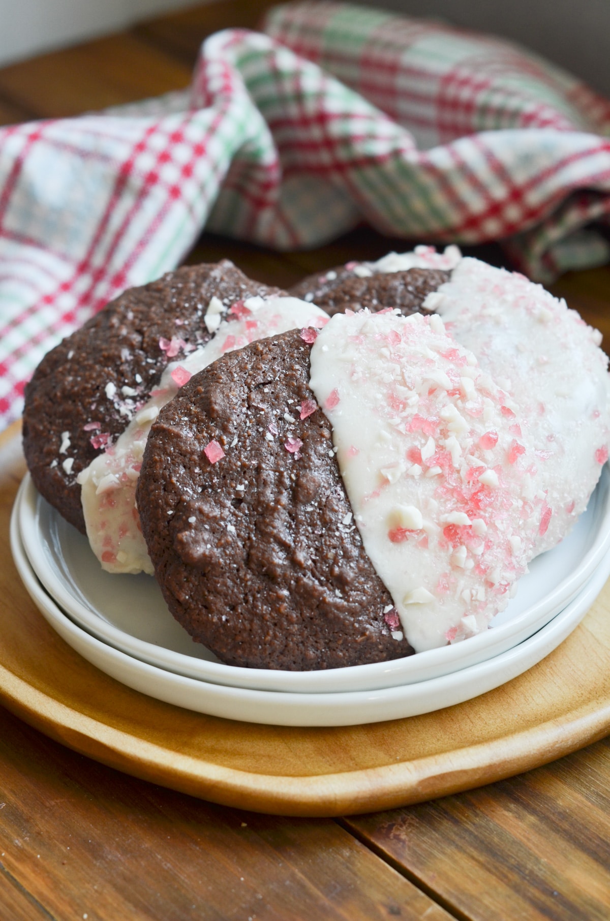 chocolate fudge cookies dipped in icing and sprinkles with crushed candy canes.