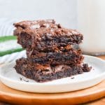 Zucchini brownies stack of three on a white plate.