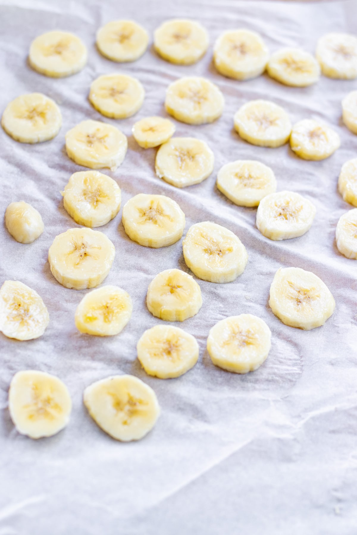 sliced bananas on parchment paper.