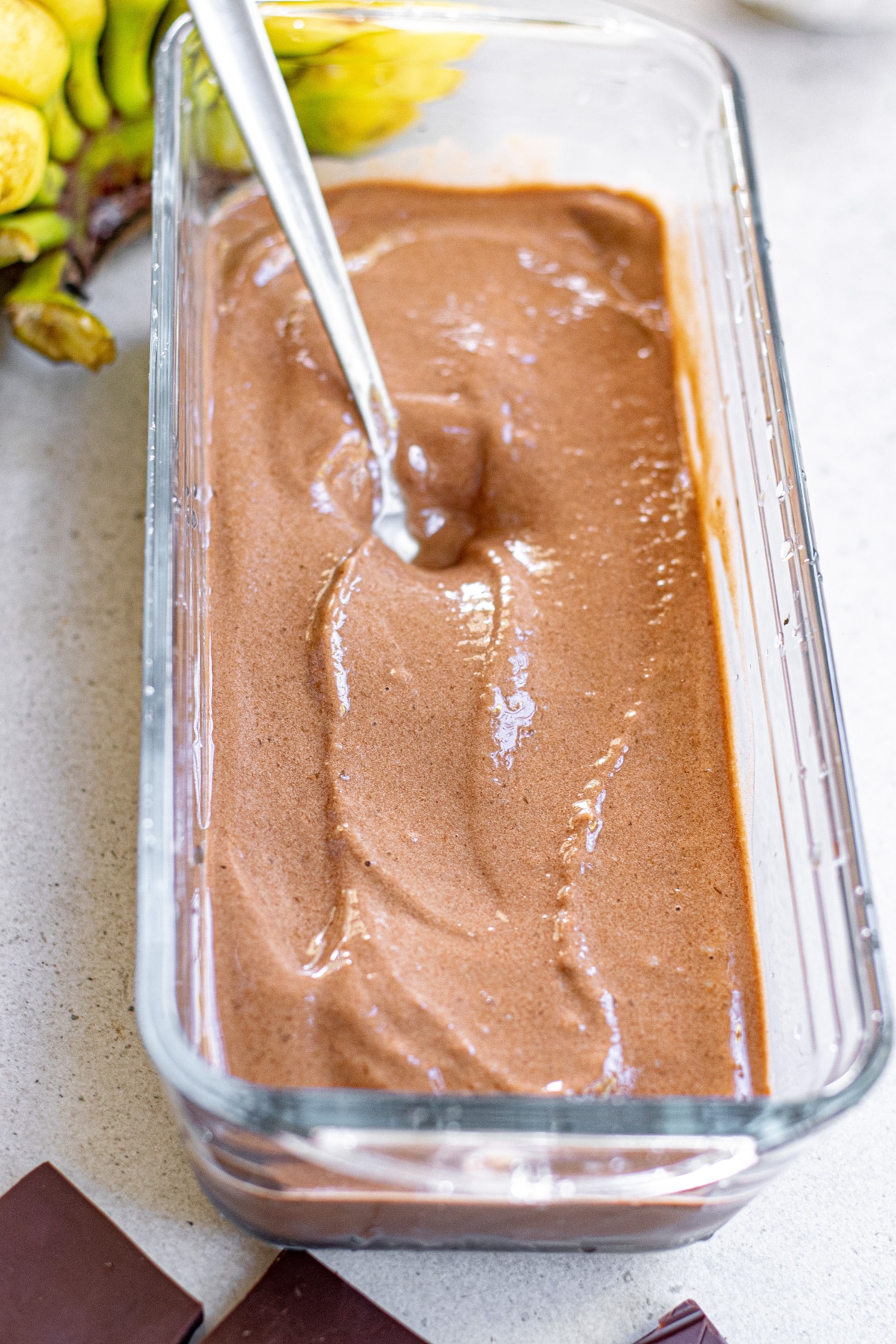 Blended chocolate banana ice cream in glass loaf pan.