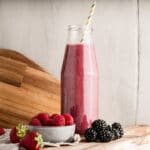 berry smoothie in a glass with straw.