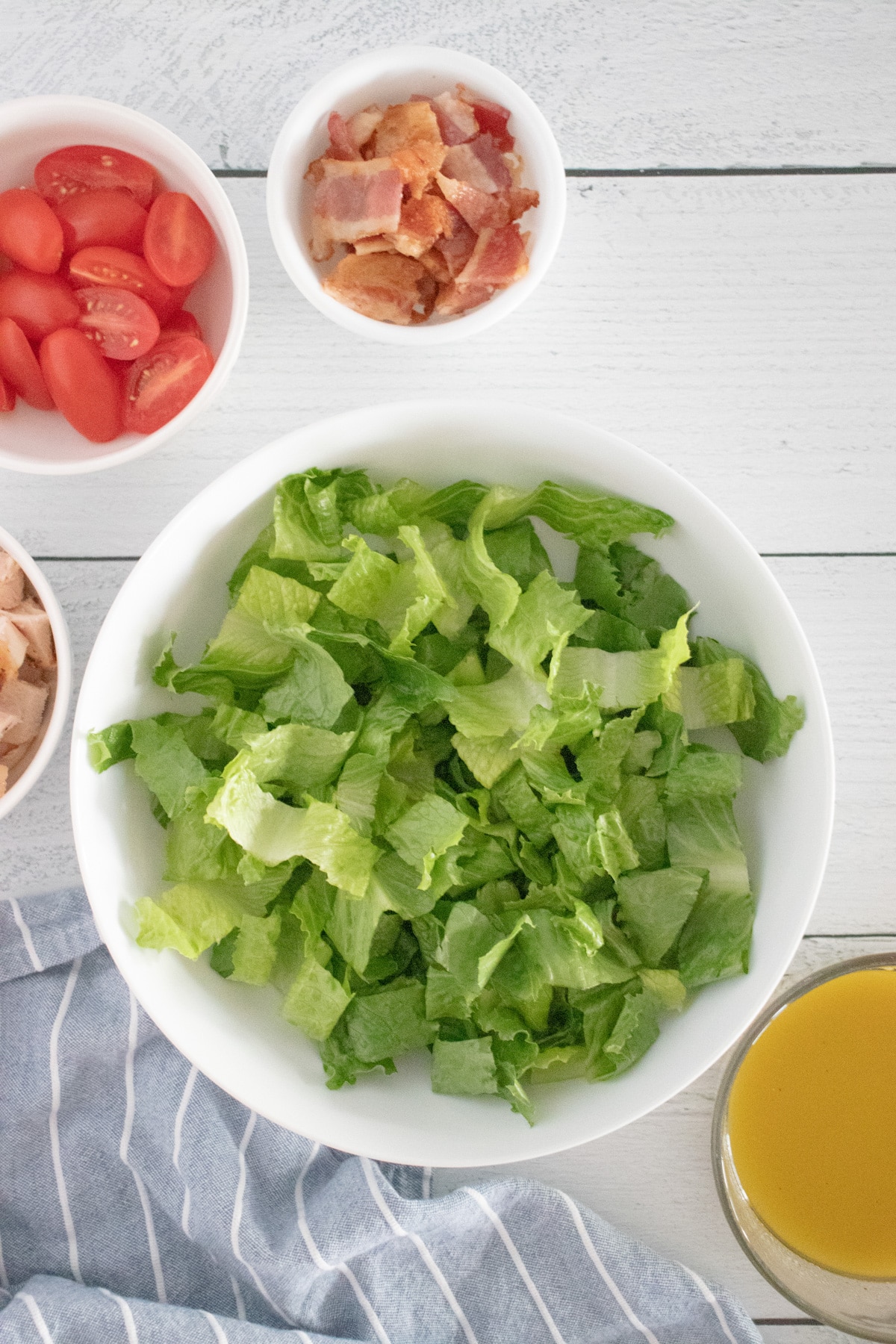 salad in bowl and other ingredients in small bowls.