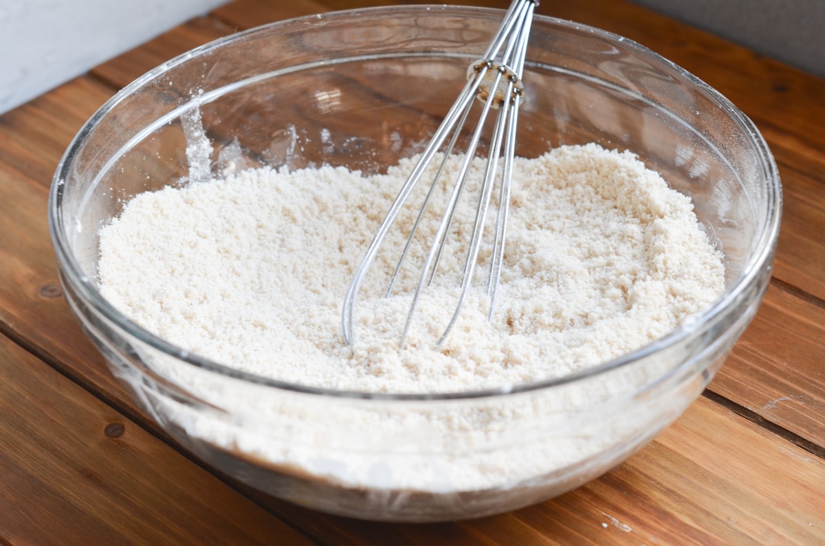 dry ingredients for gluten-free cinnamon raisin scones in mixing bowl with whisk.