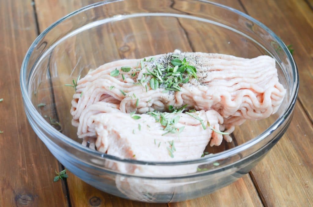 ground chicken in bowl with herbs.