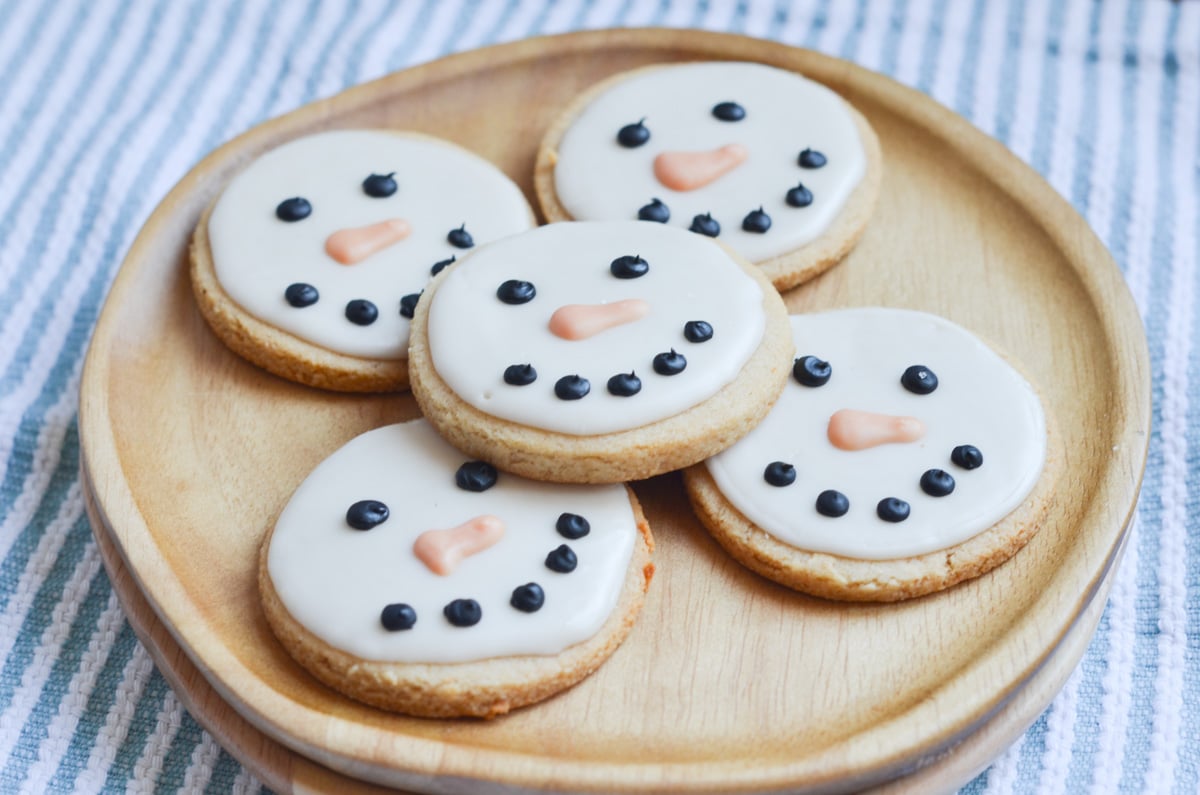 vegan Sugar Cookies Snowmen decorated on plate.