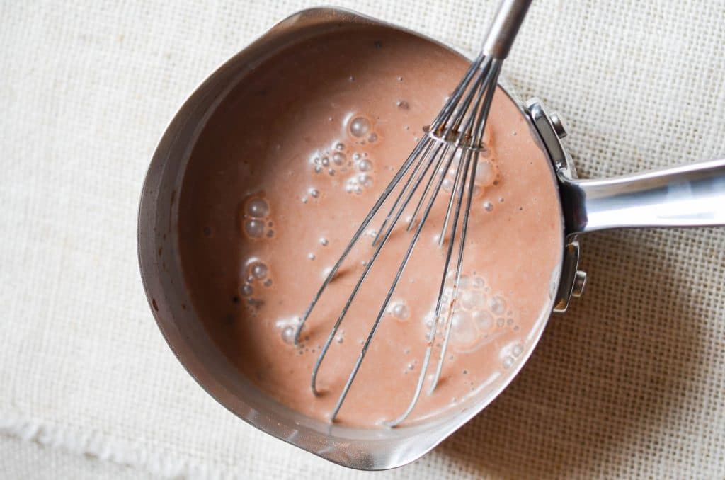 Dairy-Free Hot Chocolate in pan with whisk - 24 Carrot Kitchen