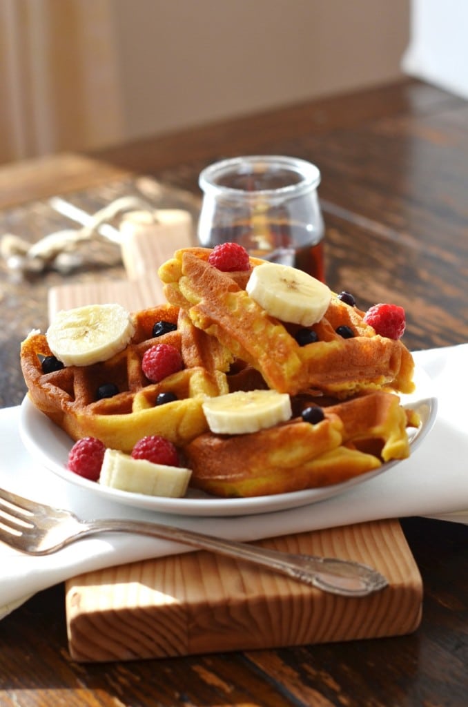 Eggless Waffles on a plate with berries and pure maple syrup - 24 Carrot Kitchen