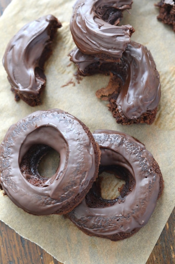 Chocolate Vegan Donuts Recipe donuts on parchment paper. - 24 Carrot Kitchen