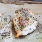 baked chicken breast on parchment lined baking pan.