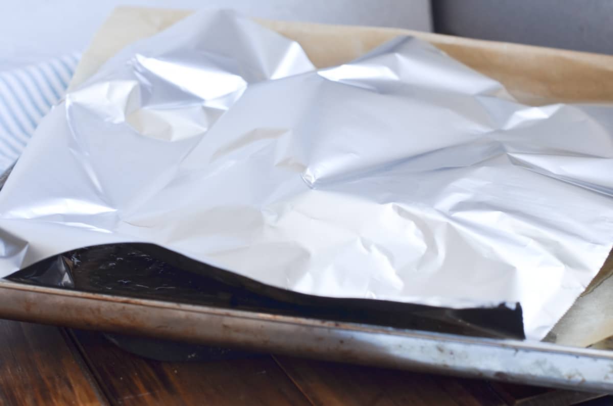 two baked chicken breasts in baking pan with aluminum foil tent over them for 10 minutes.