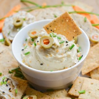 Vegan cream cheese in bowl with crackers and carrots.