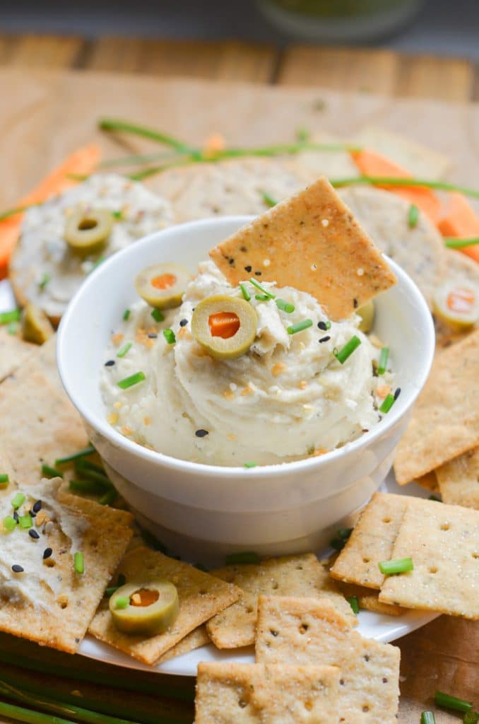 Vegan cream cheese in bowl with crackers and carrots.