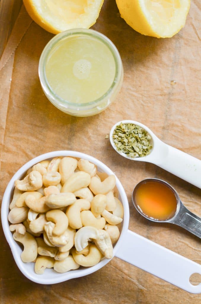 ingredients for vegan cream cheese on counter, cashews, lemon juice, chives, apple cider.