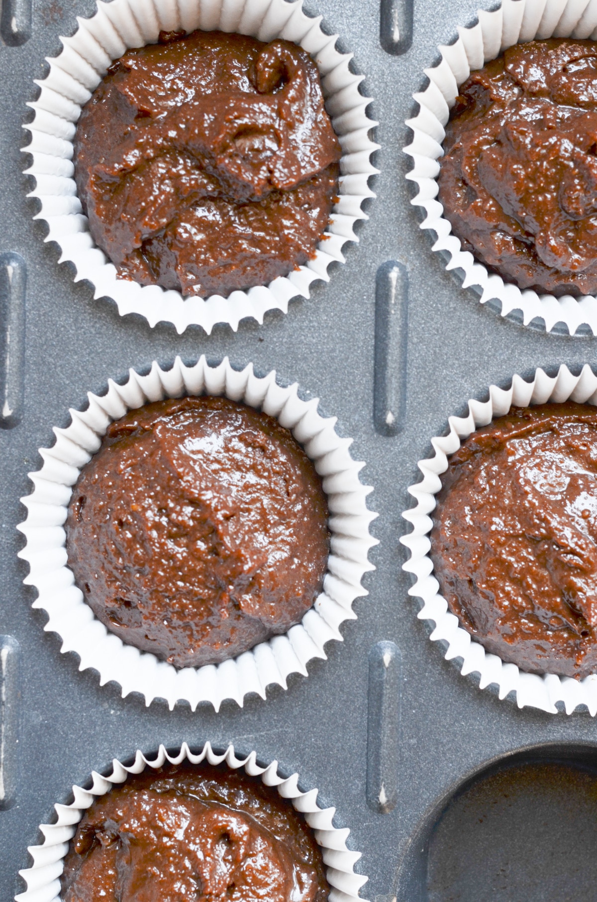 Paleo chocolate cupcakes batter in liners in muffin pan.