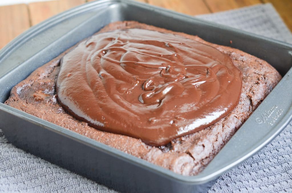 dairy-free chocolate ganache spread on square chocolate cake.