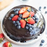 paleo chocolate cake with icing and berries.