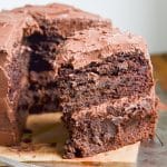 Paleo Chocolate Cake double layer frosted with one slice showing.