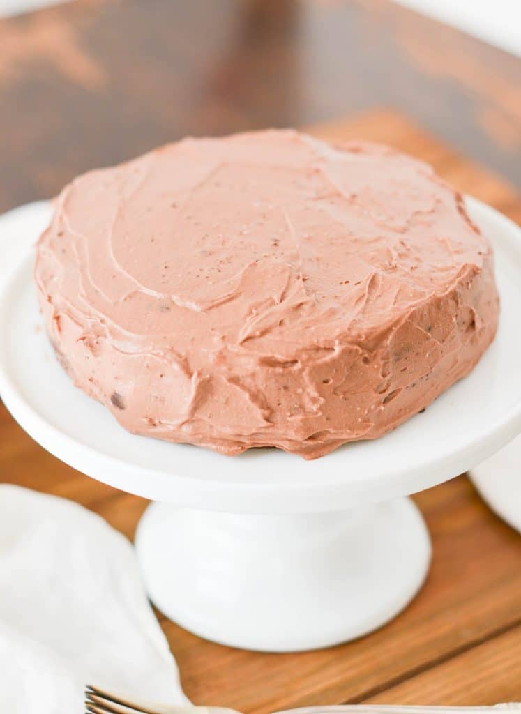 Paleo Chocolate Cake frosted with Chocolate Whipped Cream Frosting on pedestal plate. - 24 Carrot Kitchen