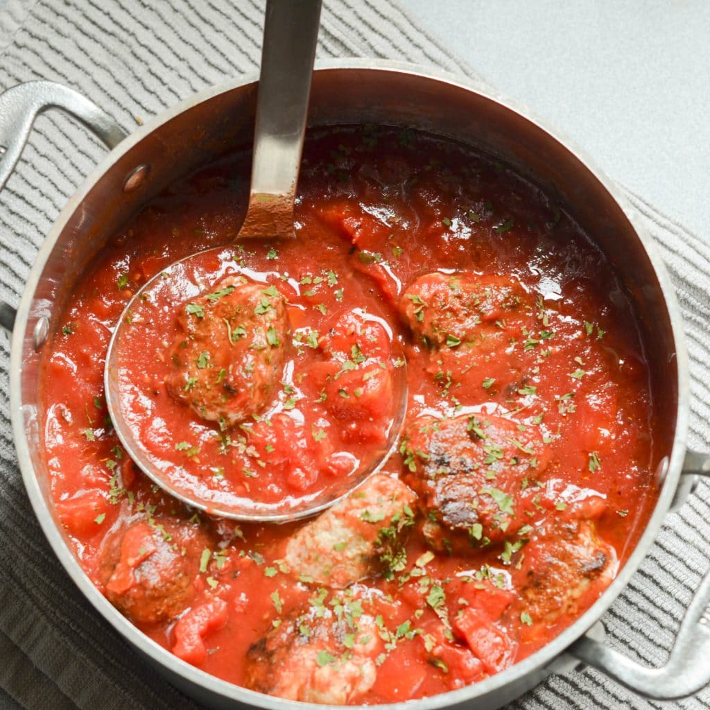 Whole30 Meatballs in pot with tomato sauce - 24 Carrot Kitchen