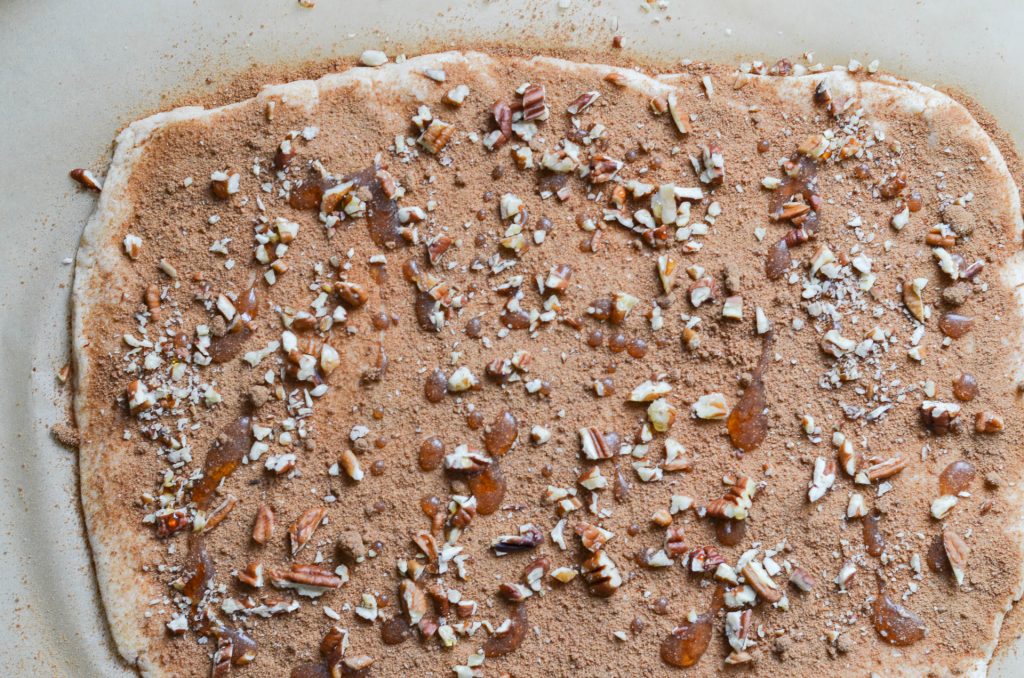 vegan cinnamon rolls dough with cinnamon sugar, chopped nuts and maple syrup - 24 Carrot Kitchen