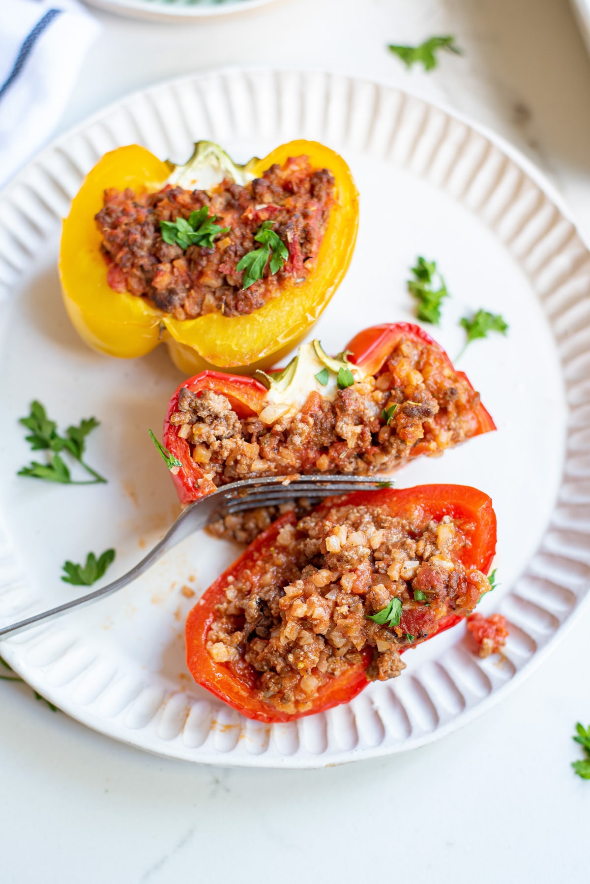 two stuffed peppers on a serving dish.