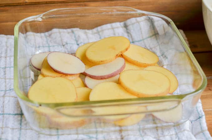 Sliced potatoes in casserole dish.