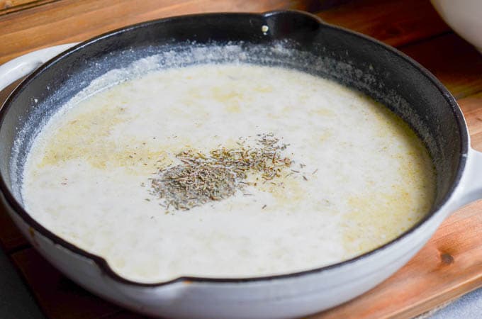 Herbs and spices added to cast iron skillet.