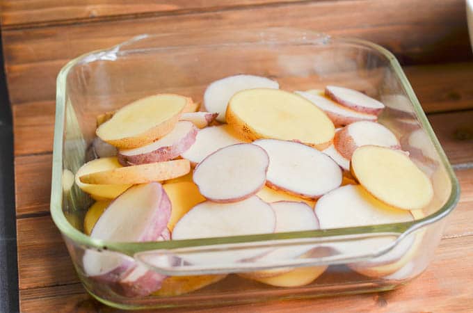 Sliced potatoes in casserole dish.