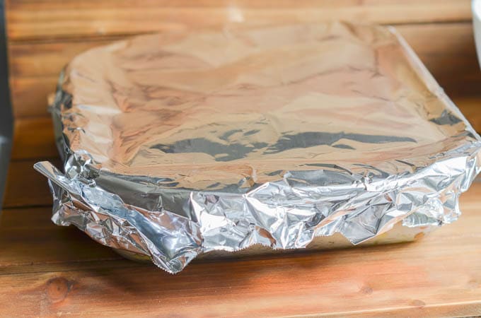 Dairy-Free Scalloped Potatoes in casserole dish covered in aluminum foil ready for oven.