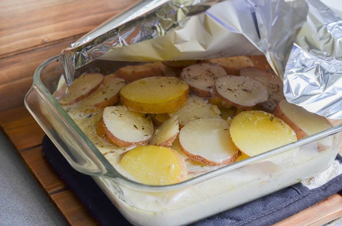 Taking aluminum foil off the dairy-free scalloped potatoes.