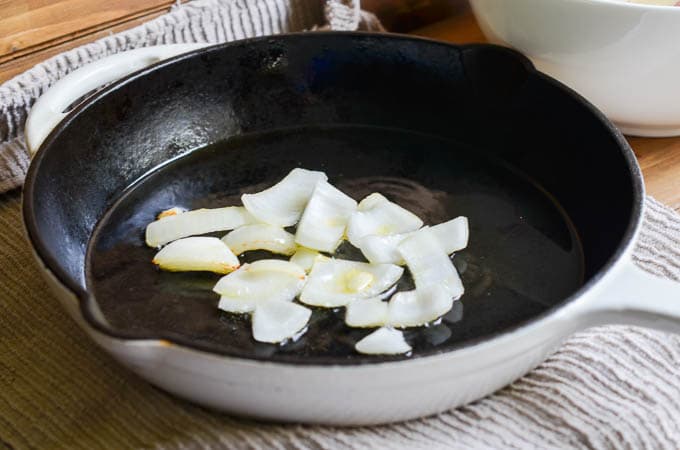 Onions cooking in cast iron skillet.