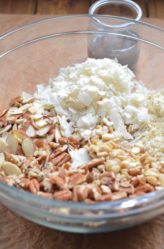 ingredients for vegan granola in glass mixing bowl.