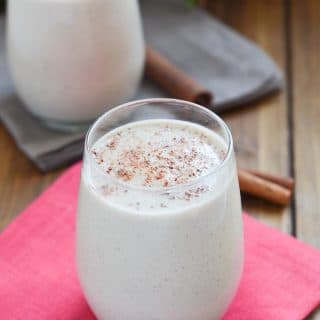 vegan eggnog in glass with sprinkle of ground nutmeg.